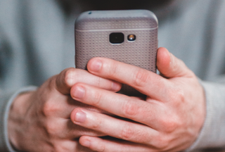 Close up of a hand holding a BYOD clinical smartphone