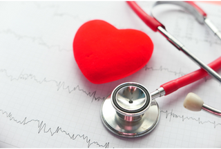 A red cartoonish heart next to a stethoscope on a piece of paper with heart readings