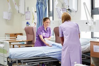 NHS staff making a hospital bed