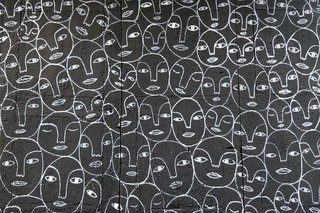 repeated faces drawn on a wall